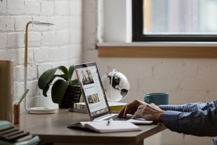 Man typing on a laptop while sitting at a desk